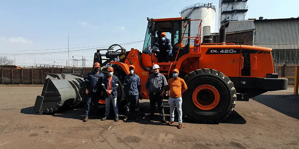 contruction team standing in front of their construction machine suppliers
