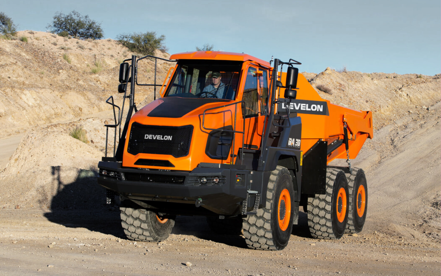 Articulated dump truck Develon DA45 driving on a construction site, showcasing advanced safety innovations and smart technology.