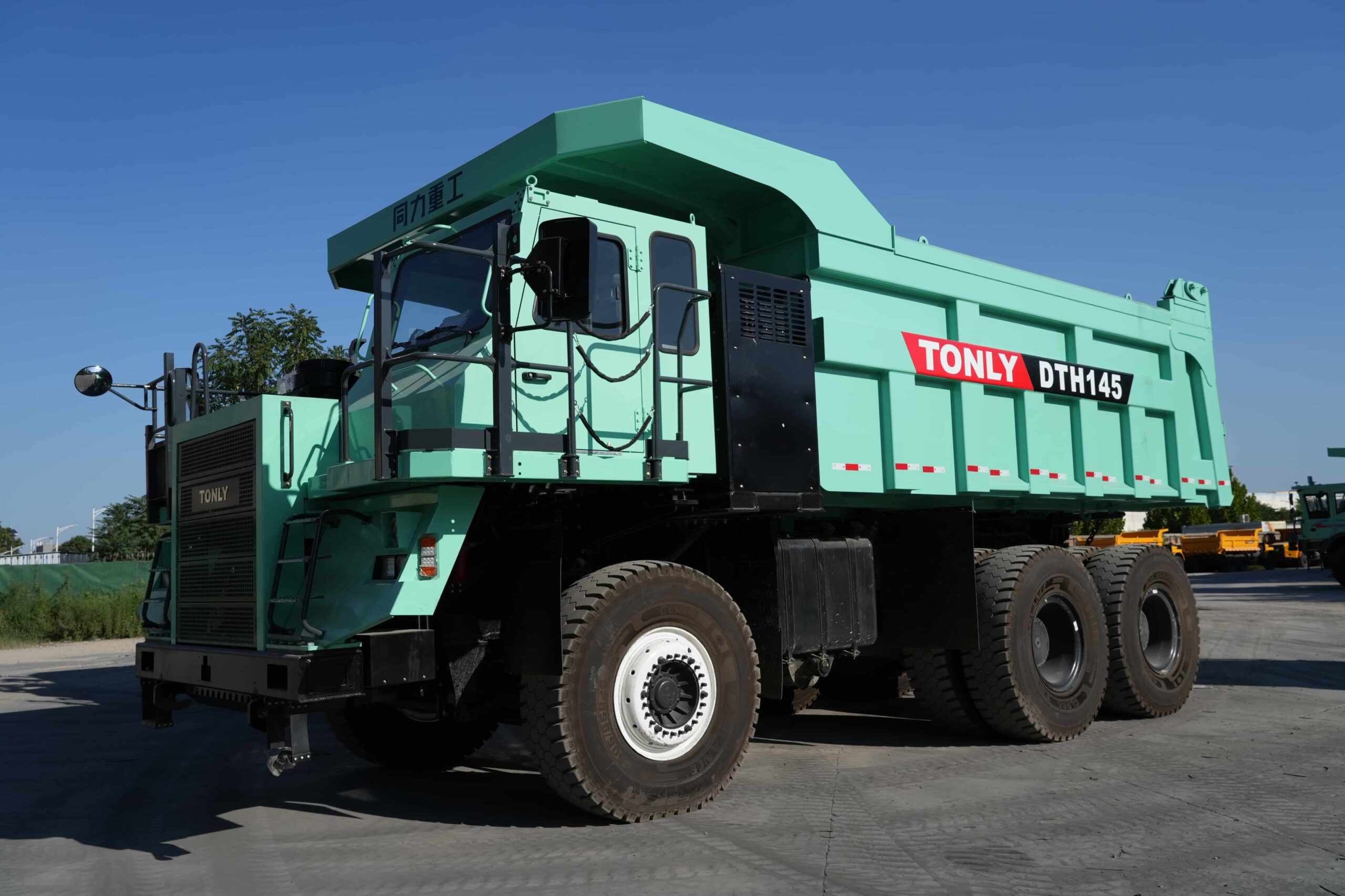A Tonly mining dump truck parked on a gravel surface under a clear sky, designed for heavy-duty off-road hauling