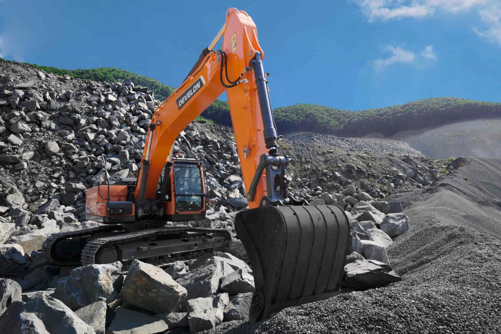 Develon excavator moving rocks in a quarry, showcasing the power and reliability offered by top construction machinery suppliers in South Africa