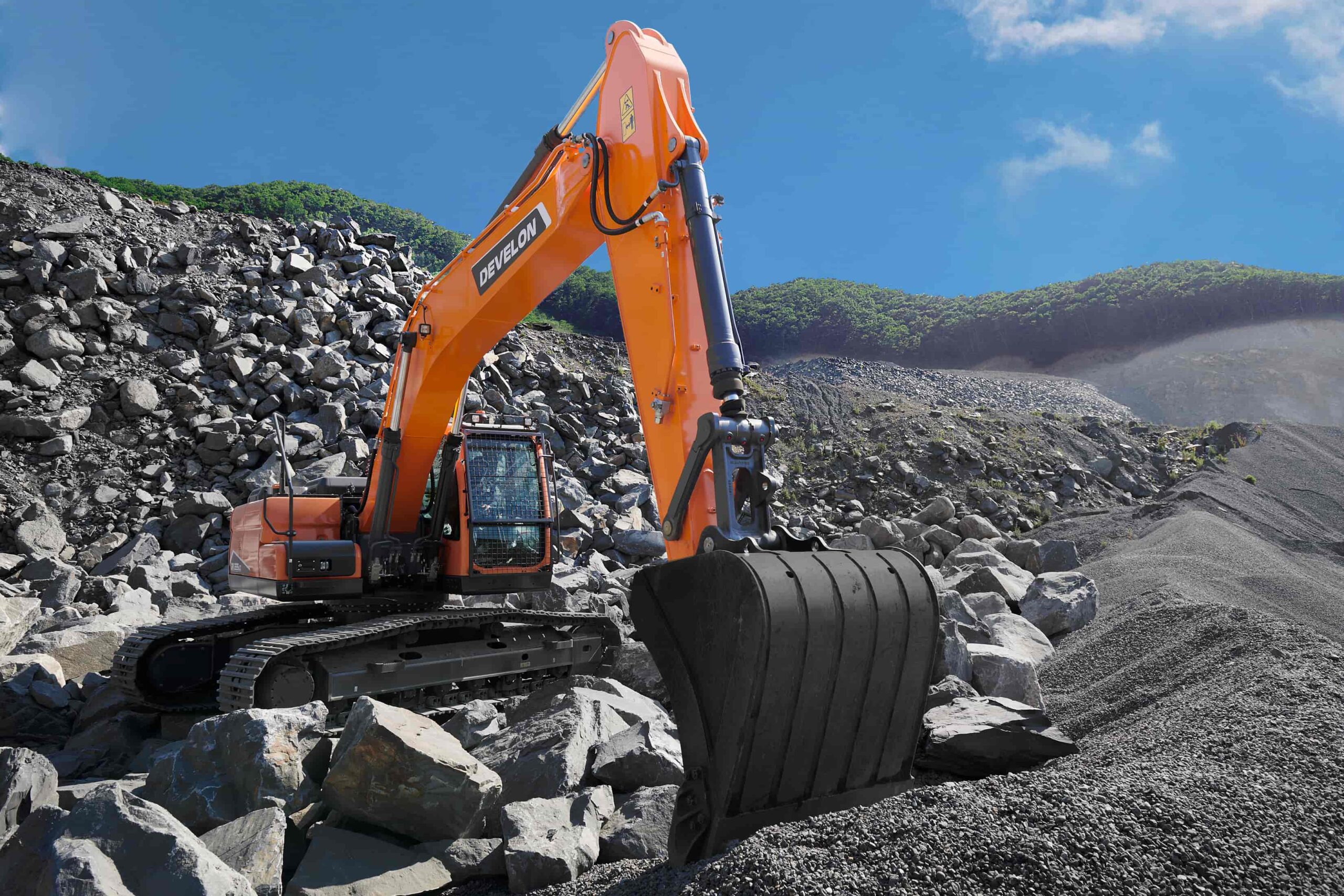 Develon excavator moving rocks in a quarry, showcasing the power and reliability offered by top construction machinery suppliers in South Africa